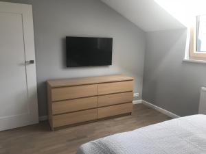 1 dormitorio con tocador y TV en la pared en Przytulny Apartament Olimpijska 1D/2b, en Szczyrk