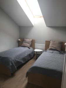 1 dormitorio con 2 camas y mesa. en Przytulny Apartament Olimpijska 1D/2b, en Szczyrk