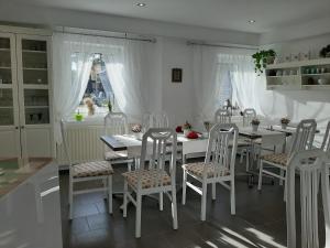 a white dining room with white tables and chairs at Pension Mark in Hoyerswerda
