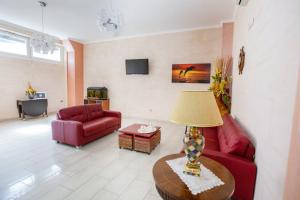 uma sala de estar com um sofá vermelho e uma mesa em Hotel Happy em Battipaglia