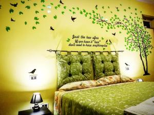 una camera da letto con un letto con un albero e uccelli sul muro di Central Isernia a Isernia