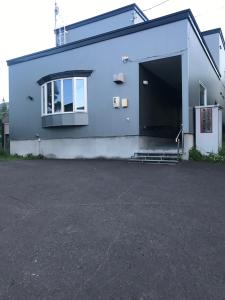 un gran edificio azul con un gran garaje en Sunny house, en Otaru