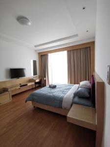 sypialnia z łóżkiem i dużym oknem w obiekcie Bernard Holiday Home 2 @ Boulevard Imperial Suite Kuching w mieście Kuching