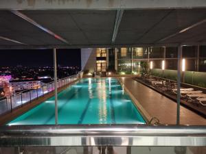 una piscina en la parte superior de un edificio por la noche en Bernard Holiday Home 2 @ Boulevard Imperial Suite Kuching, en Kuching