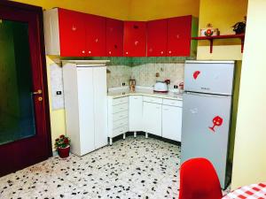 a kitchen with red cabinets and a white refrigerator at Central Isernia in Isernia