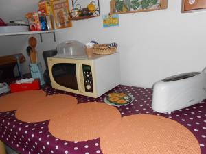 a microwave sitting on top of a kitchen floor with cookies at Les Couleurs Picardes in Aubigny