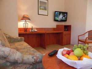 a living room with a bowl of fruit on a table at Bahnhof-Hotel Saarlouis in Saarlouis