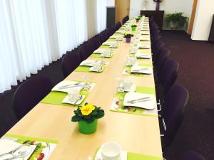 uma longa mesa com cadeiras e pratos de comida em Bahnhof-Hotel Saarlouis em Saarlouis