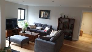uma sala de estar com dois sofás e uma televisão em 1 double guest bedroom in my home North Leeds em Horsforth