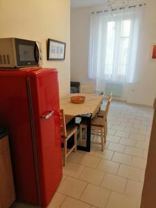 uma cozinha com uma mesa e um frigorífico vermelho em LE PETIT VENTOUX VILLAGE em Malaucène