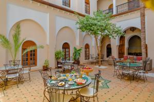 a courtyard with tables and chairs in a building at Riad Amina in Marrakesh