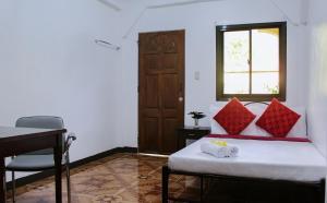 a bedroom with a bed and a desk and a window at Angel Gabriel Homestay in Coron