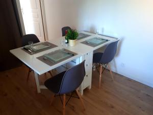 ジョネ・クランにあるFuturoscope appartement 40m2 à 7 min du parcの椅子4脚とグラスと植物が置かれた白いテーブル