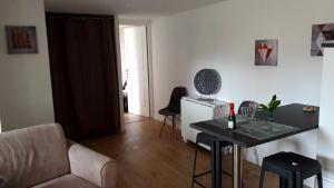 ジョネ・クランにあるFuturoscope appartement 40m2 à 7 min du parcのテーブルとソファのあるリビングルーム