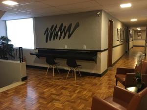 a lobby with a piano in a room with chairs at Hanna Palace Hotel in Barra do Piraí