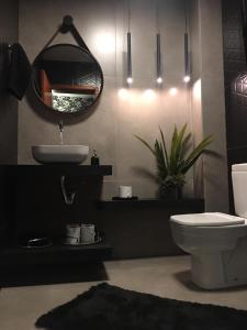 uma casa de banho com um lavatório, um WC e um espelho. em Hanna Palace Hotel em Barra do Piraí