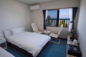 pokój hotelowy z łóżkiem i oknem w obiekcie Hotel Hoshitate Iriomotejima w mieście Iriomote