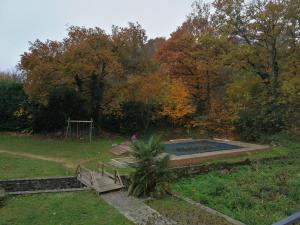 uma piscina num quintal com um banco e um parque infantil em Dolce Vita em Montfaucon