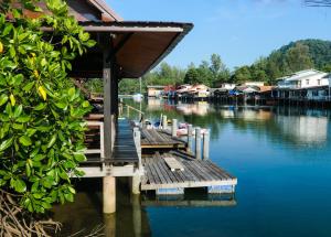 a dock on a body of water with houses at Baan Rim Nam in Ko Chang