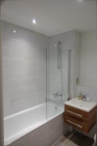 a bathroom with a shower and a tub and a sink at Luxury Birmingham City Centre Apartment in Birmingham