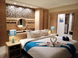 Una habitación de hotel con dos camas con cisnes. en Khaolak Blue Sky Villa, en Khao Lak