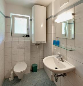 a white bathroom with a toilet and a sink at Residenz Monica Top 8 in Sankt Margarethen im Lungau