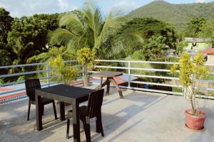 a table and chairs on a balcony with palm trees at Angel Gabriel Homestay in Coron