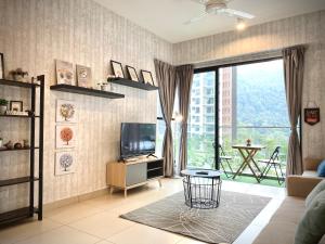 a living room with a tv and a large window at The Lakes at Midhills Genting in Genting Highlands