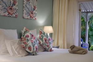 a bedroom with a bed with pillows and a window at Eight Palms in Port Edward