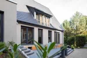 ein Haus mit schwarzen Fenstern und einem Dach in der Unterkunft Wald & Golfhotel Lottental in Bochum