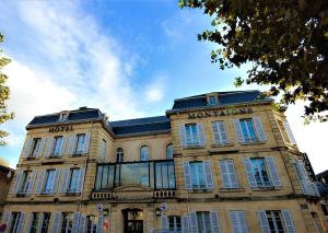 un edificio con un cartel en la parte delantera en Hôtel Montaigne en Sarlat-la-Canéda