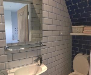 ein Badezimmer mit Waschbecken, Spiegel und Toilette in der Unterkunft Tigh Na Mara Holiday Home in Aultbea + 15 Fotos