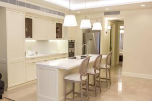 a kitchen with a large white island with chairs at SUITE WA B1 - WALDORF ASTORIA RESIDENCES - JERUSALEM-RENT in Jerusalem