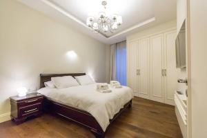 - une chambre avec un grand lit et un lustre dans l'établissement SUITE WA B1 - WALDORF ASTORIA RESIDENCES - JERUSALEM-RENT, à Jérusalem