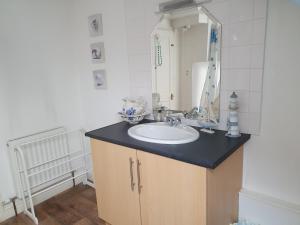 La salle de bains est pourvue d'un lavabo et d'un miroir. dans l'établissement Chartwell Retreat, à Whitby