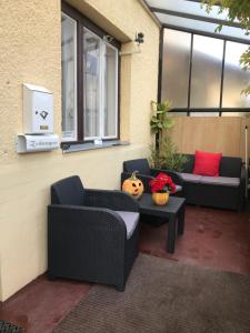 a patio with two chairs and a table and a window at Apartman Danka in Bük