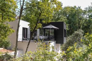 ein schwarzes Haus mit Balkon und Sonnenschirm in der Unterkunft Villa Nakalta in CazoulÃ¨s