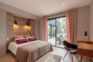 a bedroom with a bed and a desk and a window at Villa Nakalta in CazoulÃ¨s