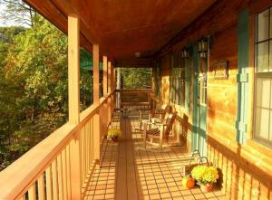 a porch of a house with a table and chairs at Sunset Ridge Cabin in Pigeon Forge