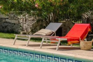a hammock and a chair next to a swimming pool at Mas d'Escattes in Nîmes