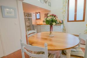 - une table à manger avec un vase de fleurs dans l'établissement Duplex au coeur du vieil Antibes, à Antibes