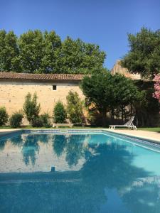 a swimming pool in front of a building at Mas d'Escattes in Nîmes