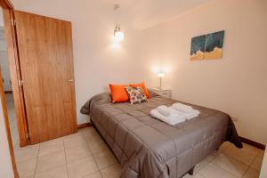 1 dormitorio con 1 cama con 2 toallas en Appartement in the Main Street with elevator access en Ushuaia