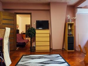 un salon avec une télévision sur une commode dans l'établissement Woody - Cozy and Quiet Place near Moghioros Park, à Bucarest