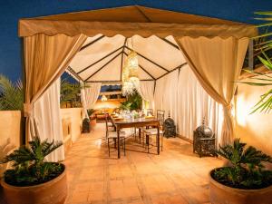 uma sala de jantar com uma mesa e uma tenda em Riad Selouane em Marrakech