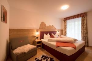 una camera con un letto e una sedia e una finestra di Residence Sisi a Ortisei