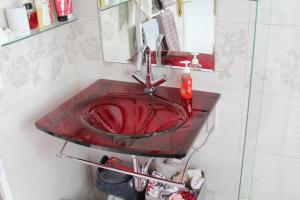 La salle de bains est pourvue d'un lavabo rouge et d'un miroir. dans l'établissement Holiday Home Magnolia, à Trakošćan