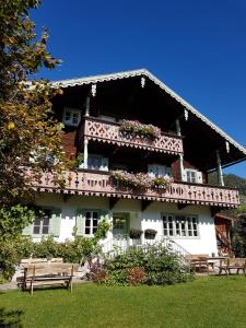 a large white building with flowers on the front at Villa Zeppelin - App Bergkristall in Bramberg am Wildkogel