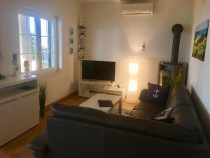 a living room with a couch and a television at Schönes Ferienhaus direkt am Meer in Stomorska