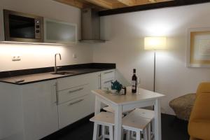 a kitchen with a table with a bottle of wine on it at Aromas dos Salgueiros in Castelo de Vide